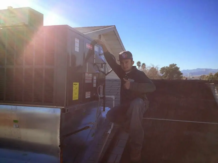 HVAC technician performing HVAC Inspection on a rooftop unit in Randolph